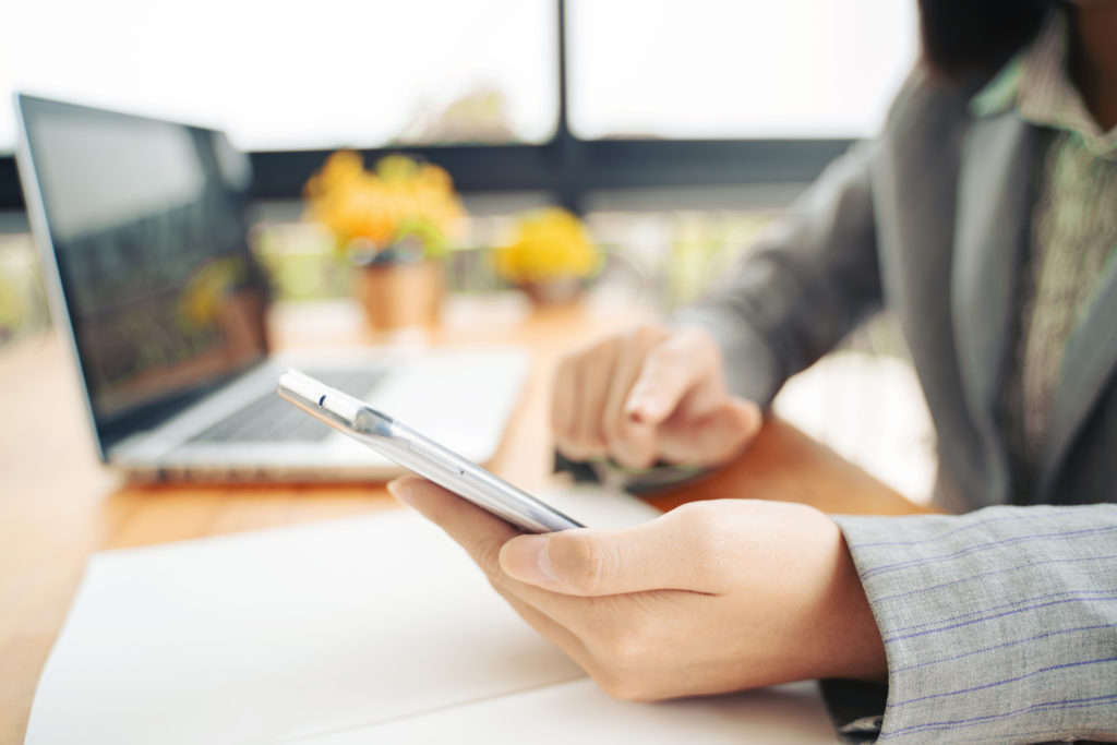 Woman using phone and computer